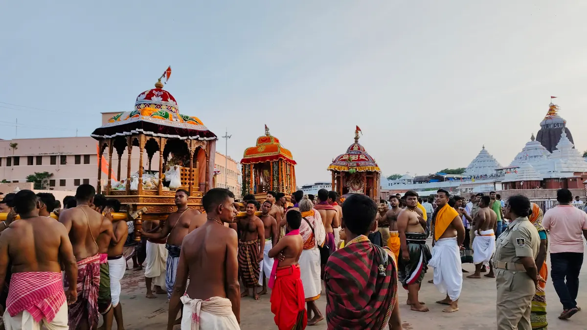 Decorated palanquins carried through the crowd outside the Jagannath temple in Puri during Chandan Yatra