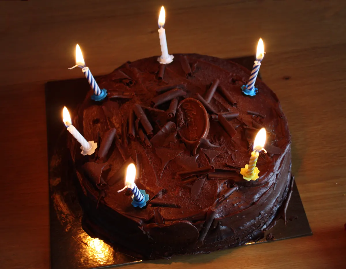 Chocolate birthday cake with lit candles