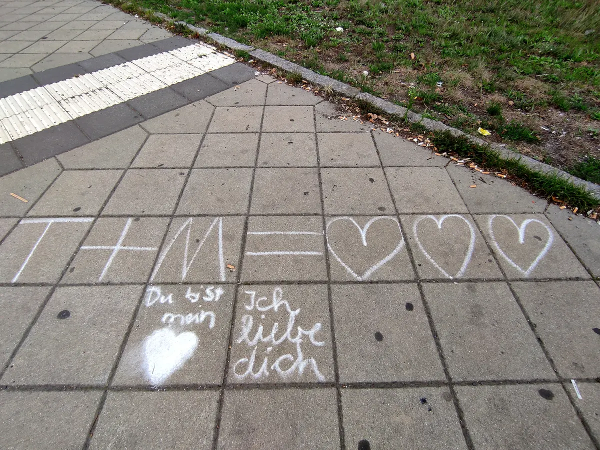 A chalk declaration of love with hearts written on a pavement