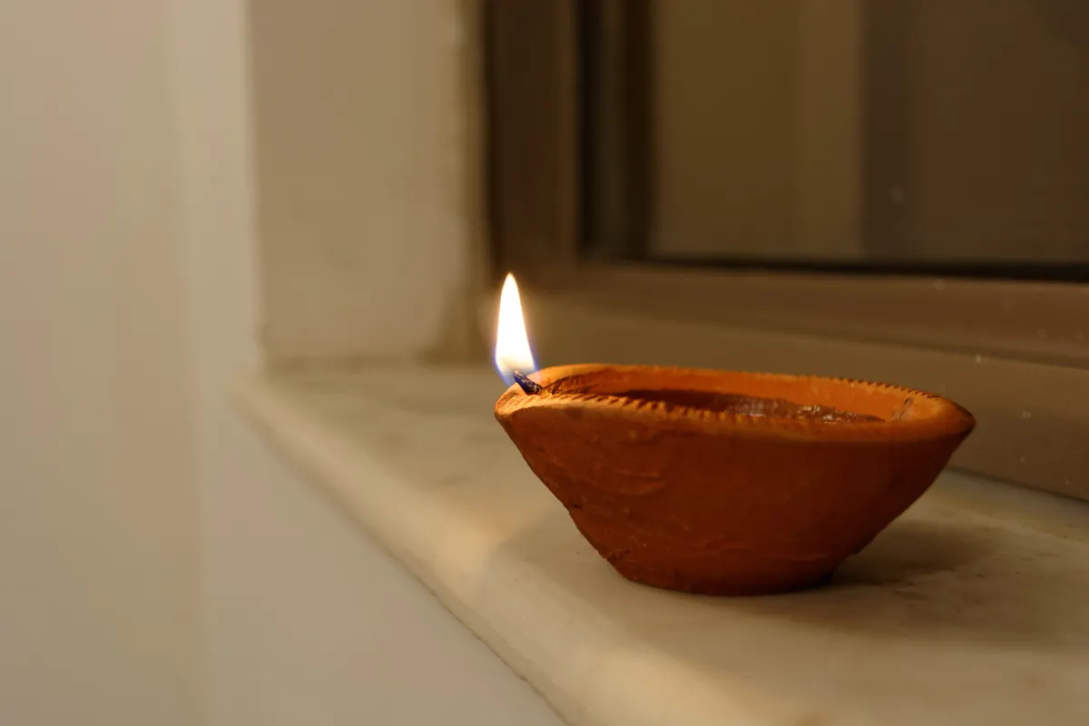 A glowing clay diya on Diwali night