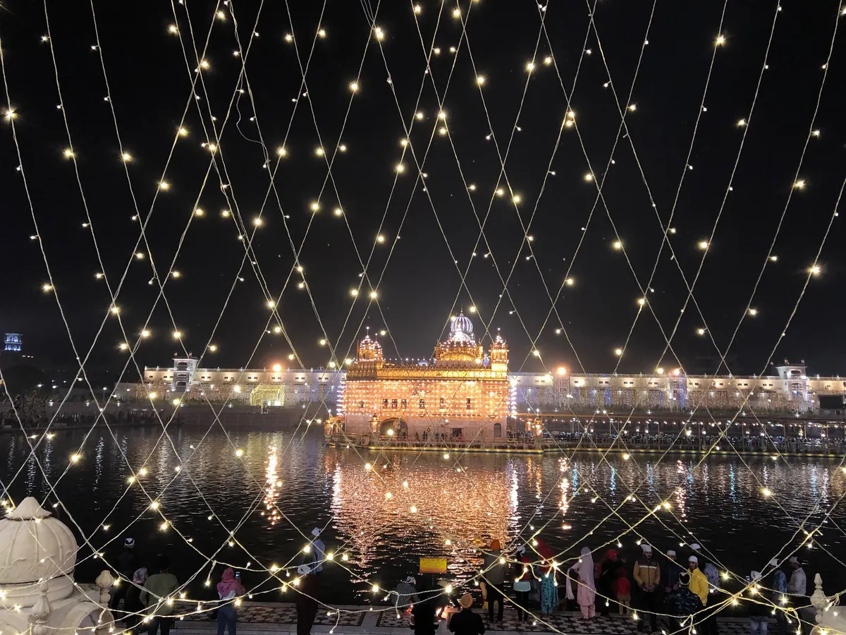 Golden Temple in Amritsar lit up with strings of lights at night for Gurpurab