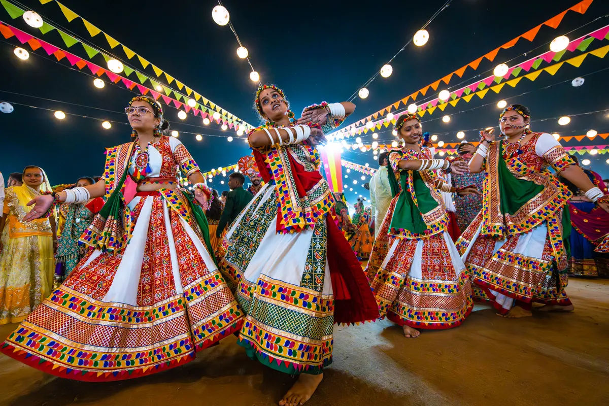 Dancers in colourful traditional dress performing garba on a Navratri night