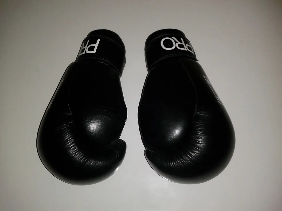A pair of black boxing gloves on a white table