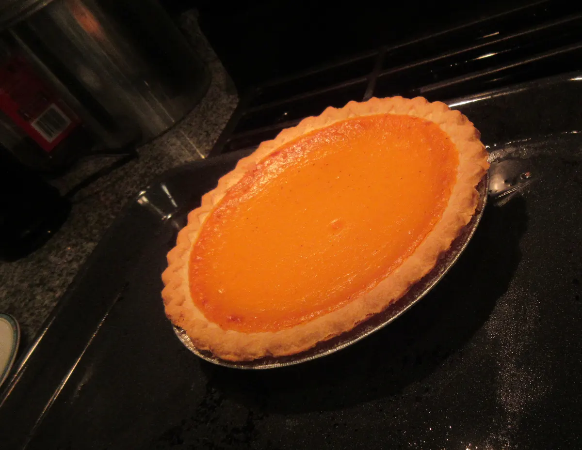 Homemade pumpkin pie in a baking dish ready for Thanksgiving dinner