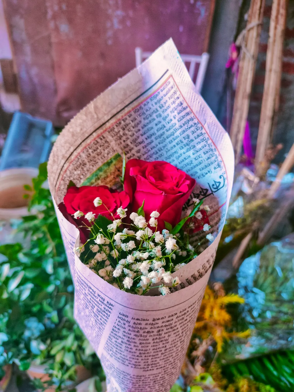 Red roses and baby's breath wrapped in newspaper as a bouquet